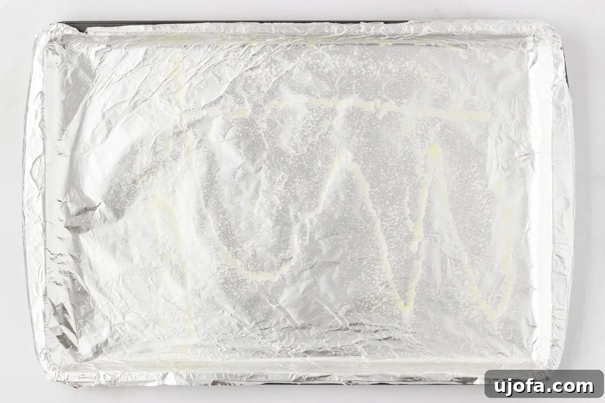 Foil-lined baking sheet lightly sprayed with oil, ready for baking meatballs.