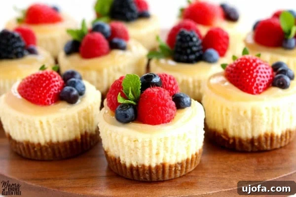 Guilt-Free Mini Cheesecake Bites 6 Ten delightful gluten-free mini cheesecakes, beautifully topped with tangy lemon curd and a medley of fresh berries, creating an inviting and colorful dessert display.