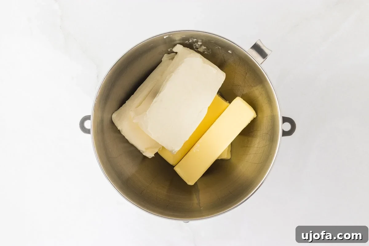 A mixing bowl with blocks of cream cheese and butter, ingredients for the cream cheese frosting.