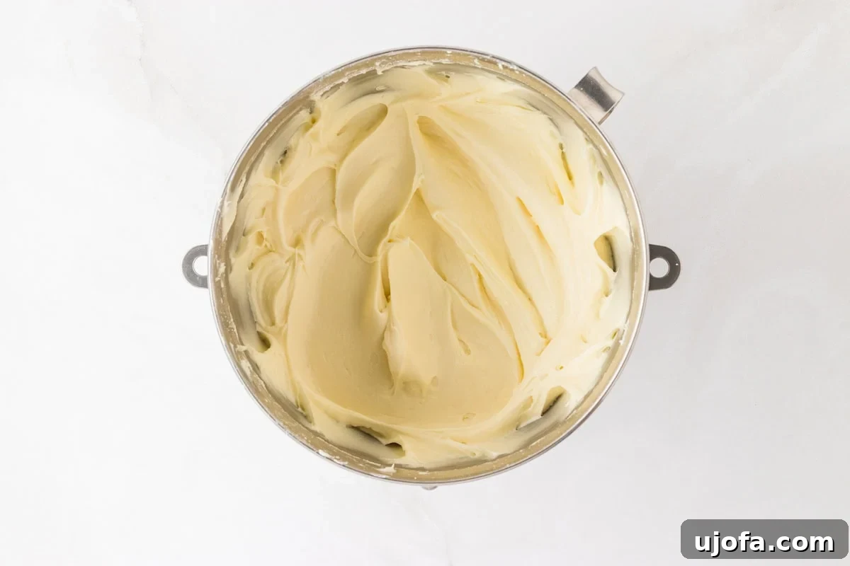A mixing bowl with cream cheese frosting fully mixed, showcasing a smooth and creamy texture.