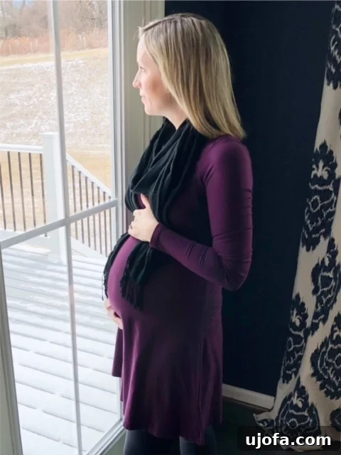 Thriving Beyond Postpartum Anxiety 6 Pregnant woman in her third trimester smiling and cradling her baby bump.