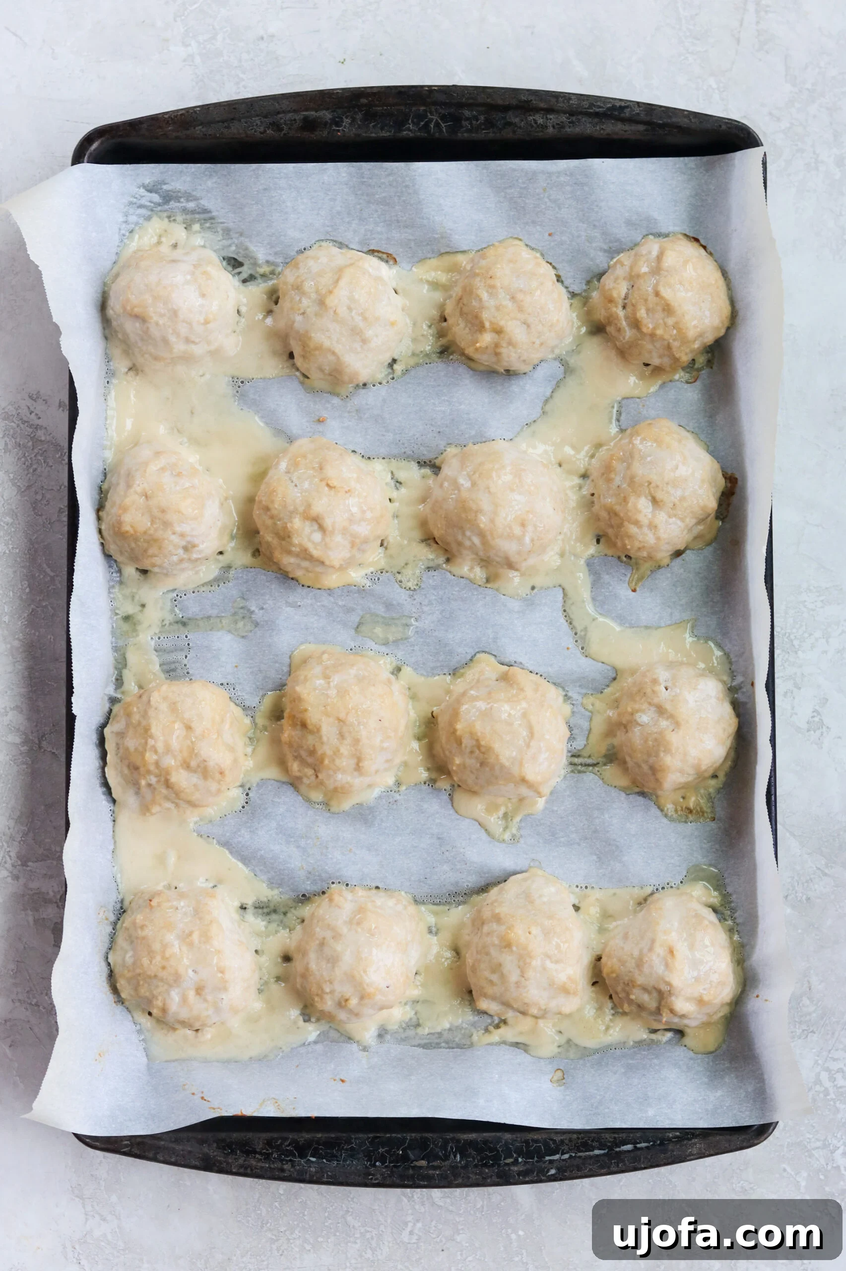 Paleo Butter Chicken Meatball Bake 3 ground chicken meatballs with no breadcrumbs on a baking sheet with parchment paper