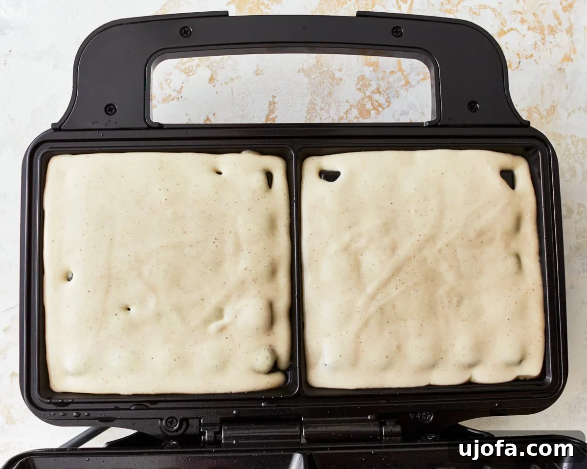 gluten-free waffle batter in a waffle iron.