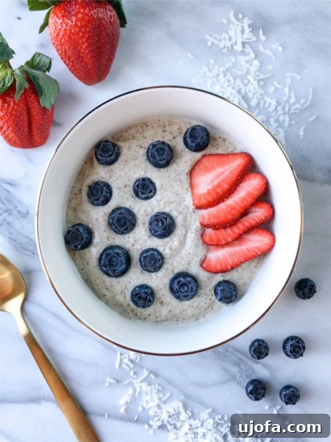 Macadamia Morning Delight 2 Warm Macadamia N'oatmeal served in a bowl, garnished with fresh berries and coconut flakes.