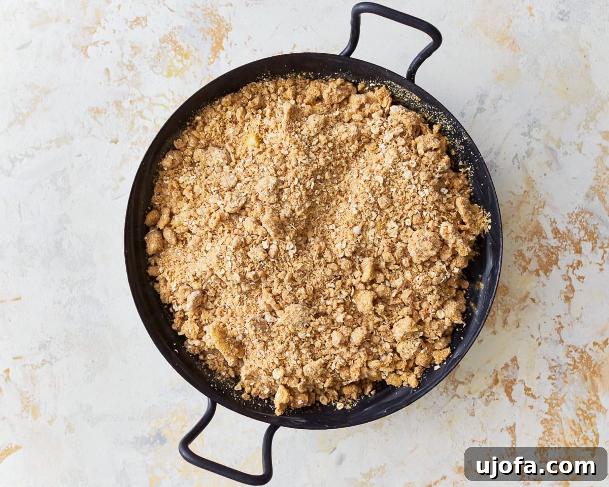 Gluten-free apple crisp, with the crumb topping sprinkled over the apple filling, ready for the oven.