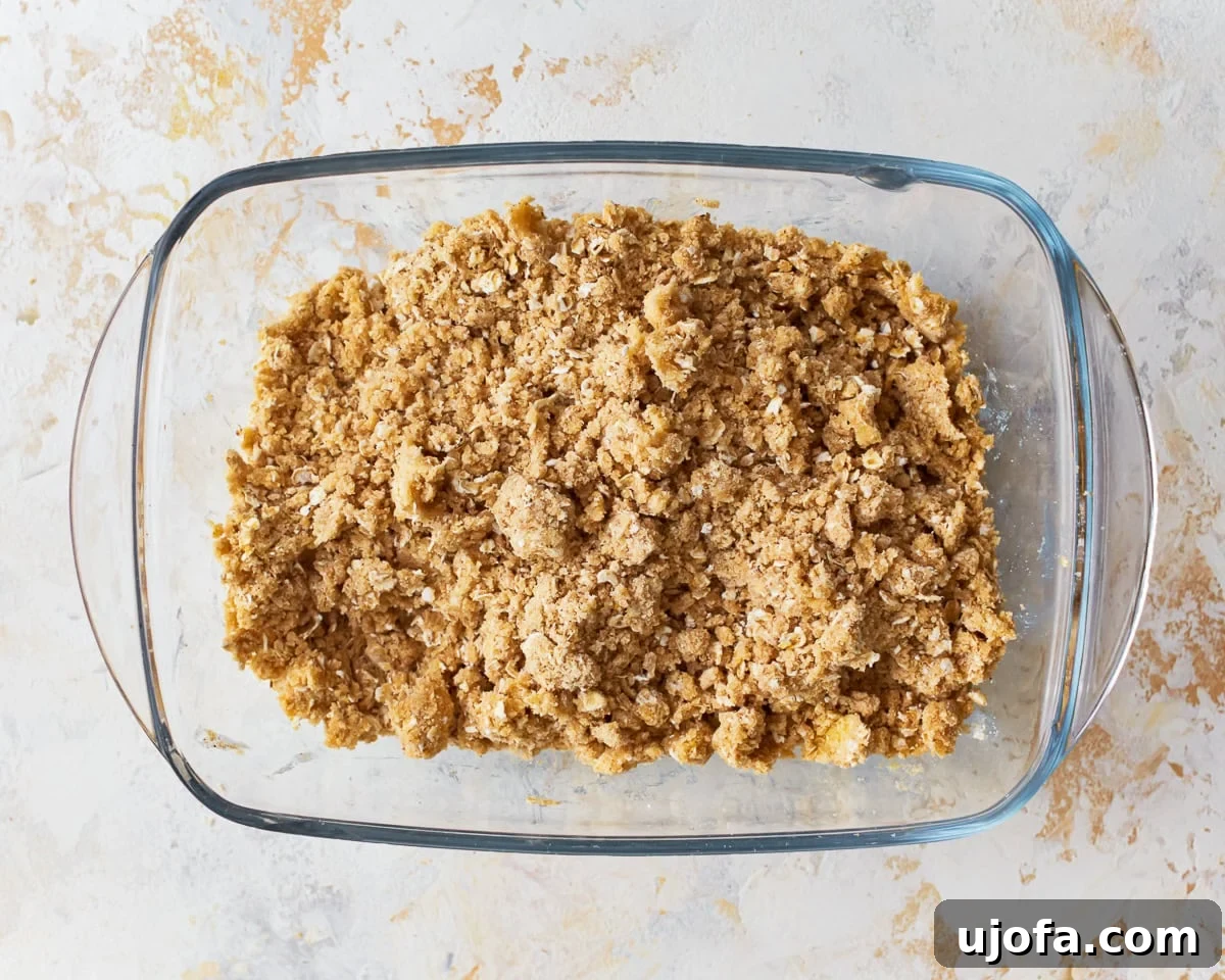 Crumb topping ingredients for gluten-free apple crisp mixed in a glass bowl, ready to be chilled.
