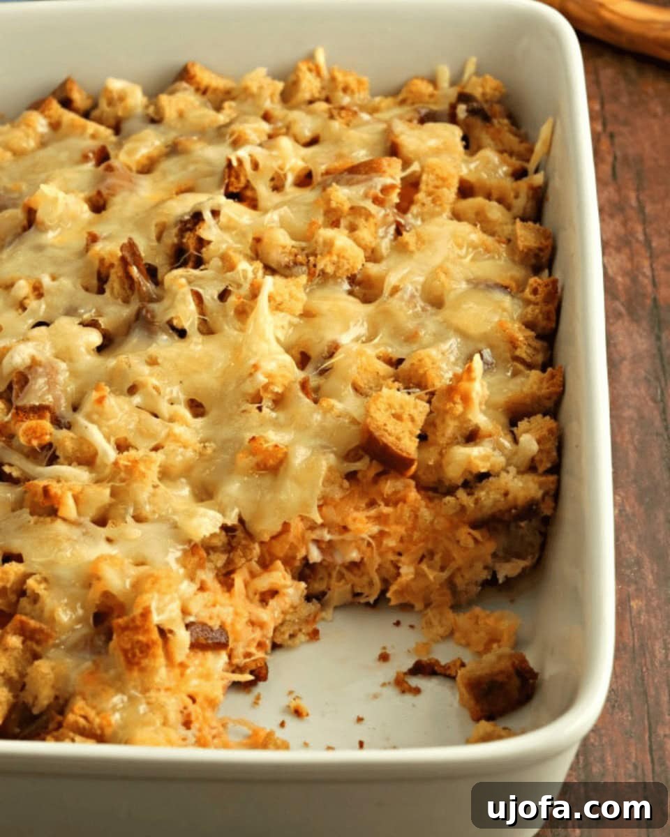 Ultimate Gluten-Free Reuben Bake 2 Gluten-free Reuben casserole baked in a white baking dish with melted Swiss cheese and toasted bread cubes on top.