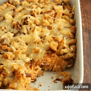 Gluten-free Reuben casserole baked in a white baking dish with melted Swiss cheese and toasted bread cubes on top.