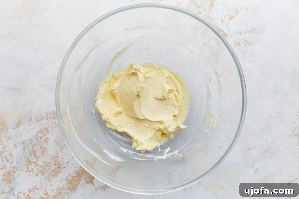Guilt-Free Chocolate Indulgence 14 Creamy mixture of butter and extracts in a clear bowl, light and fluffy, prepped for cocoa powder and sugar.