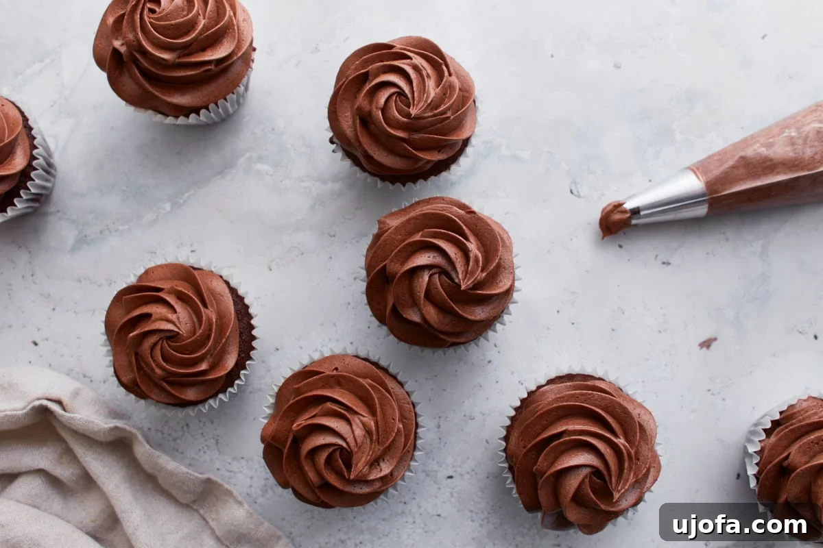 Guilt-Free Chocolate Indulgence 19 Overhead shot of frosted gluten-free chocolate cupcakes on a marble surface, with a piping bag to the side.