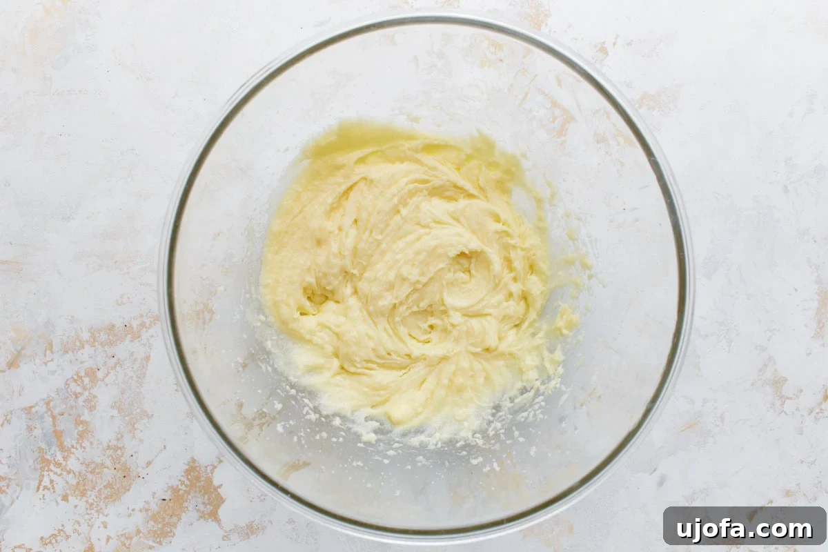 Guilt-Free Chocolate Indulgence 6 Glass mixing bowl with a light, fluffy mixture of creamed butter and sugar, shown from overhead on a neutral background.