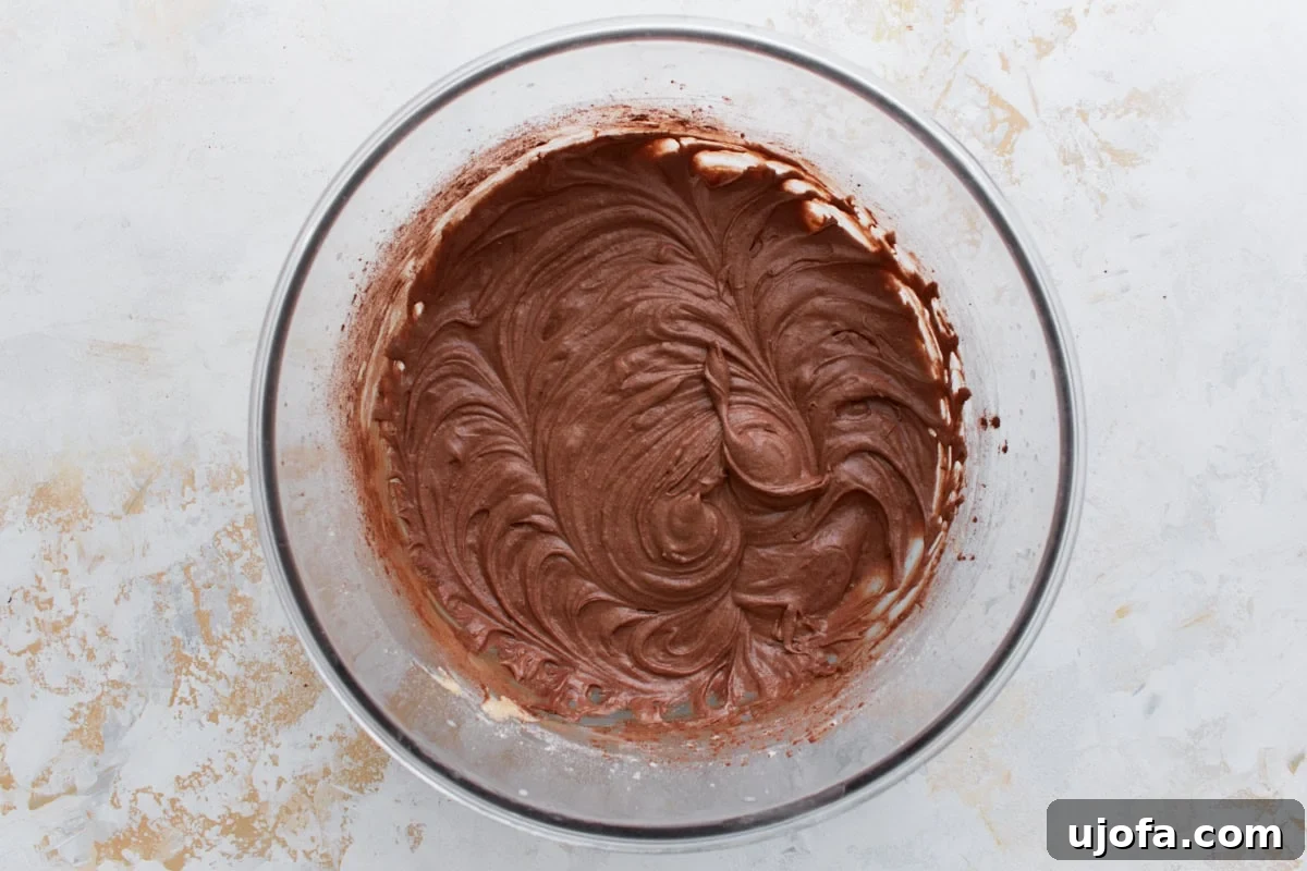 Guilt-Free Chocolate Indulgence 9 Smooth, rich chocolate cupcake batter swirled in a glass mixing bowl after cocoa powder has been added.