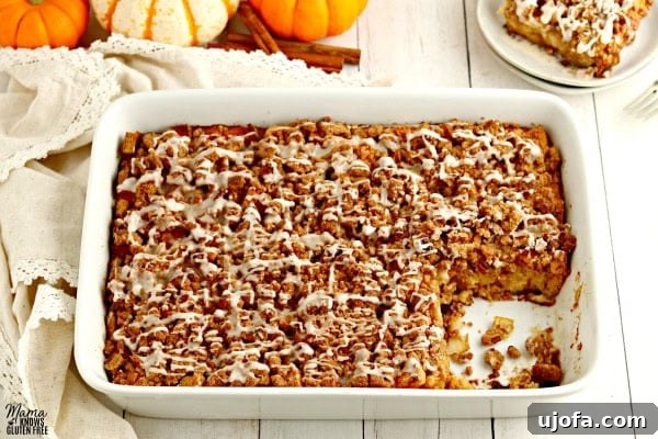 Autumn Spice Gluten-Free Pumpkin French Toast Bake 6 A large pan of gluten-free pumpkin French toast casserole with one slice neatly cut out, showcasing the delicious layers and texture.