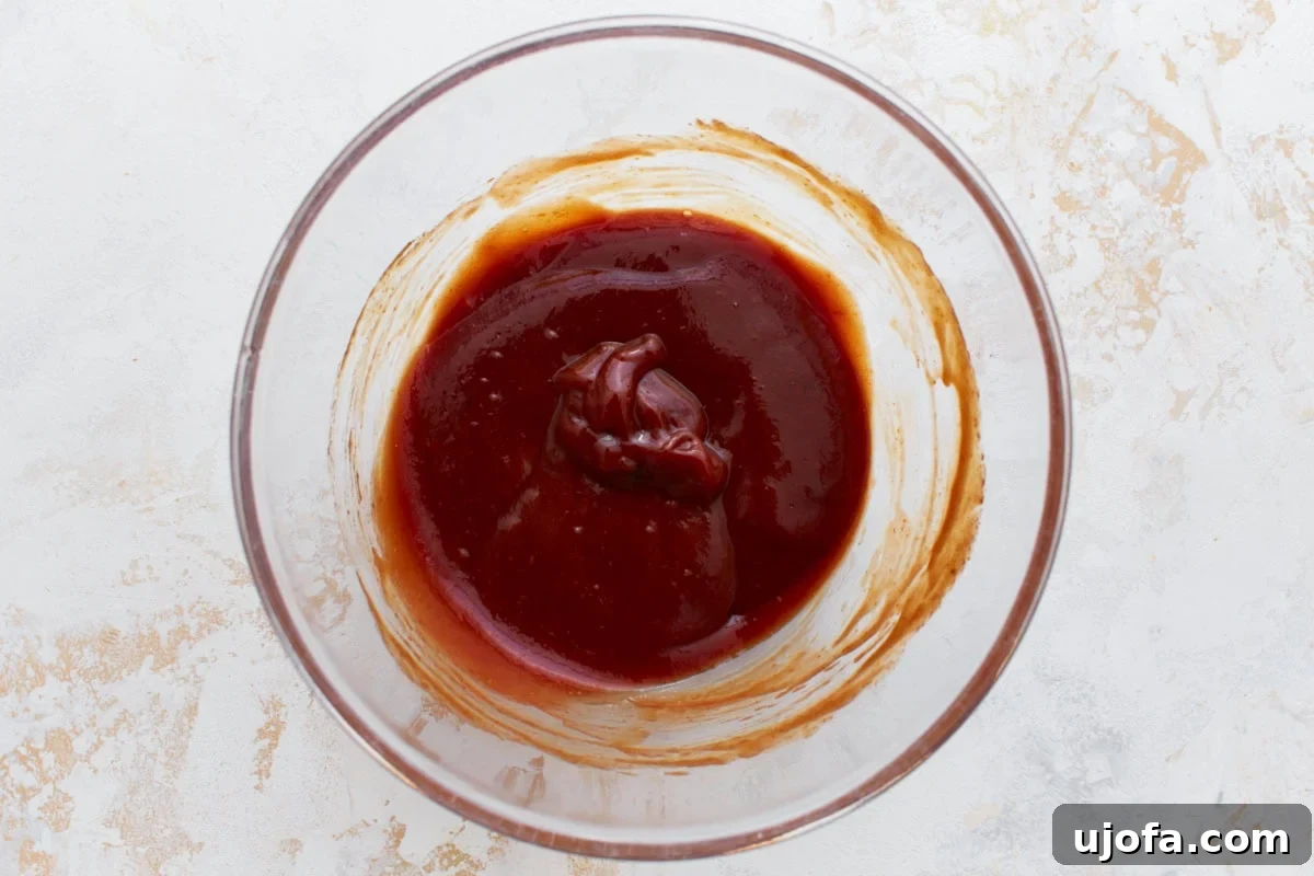 A bowl of sweet and tangy glaze mixture, ready to be spread on the meatloaf.