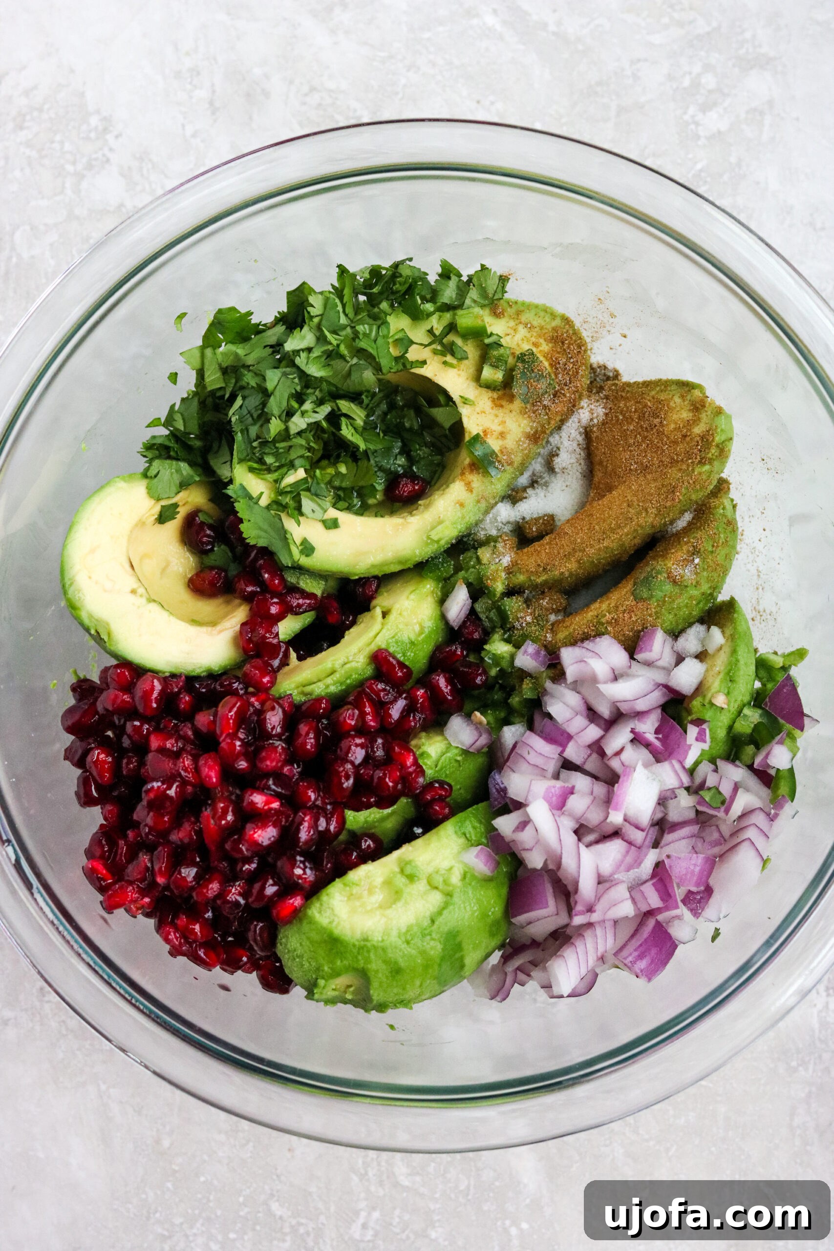 Vibrant Pomegranate Guacamole 3 Fresh ingredients laid out in a glass bowl, ready for making easy pomegranate guacamole