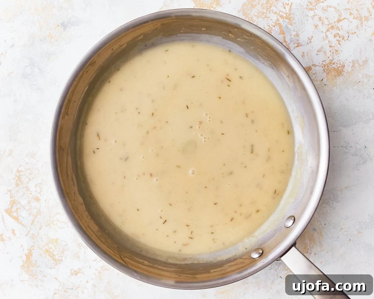 Gluten-free gravy simmering in a small saucepan, seasoned and ready to serve.