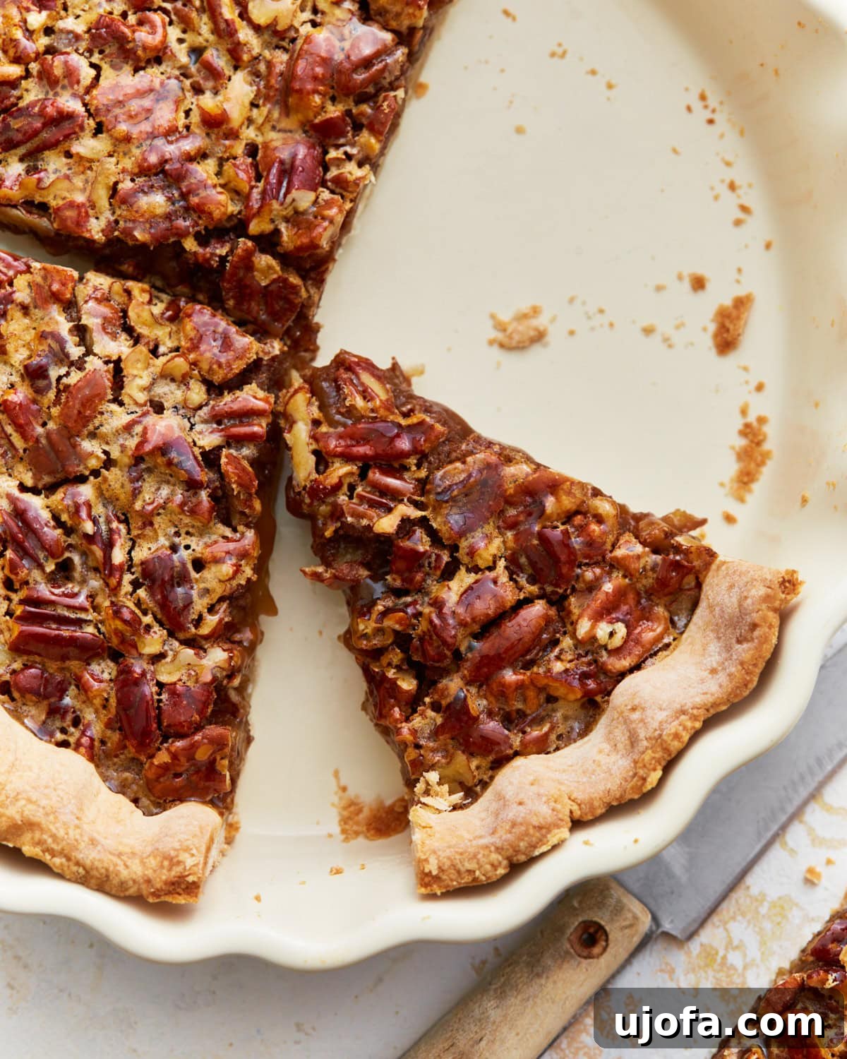Overhead view of several slices of gluten-free pecan pie arranged neatly in a pie dish, highlighting its texture and rich color.