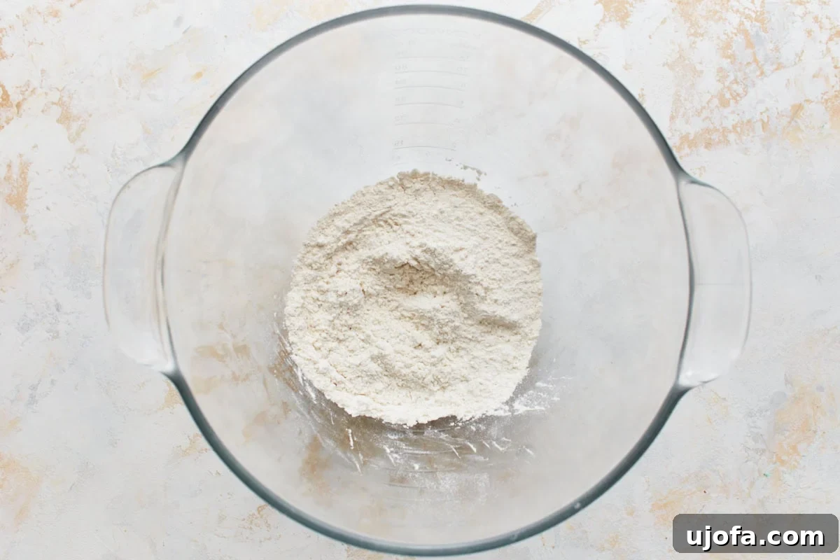 Gluten-free flour in a clear glass mixing bowl, ready for baking.