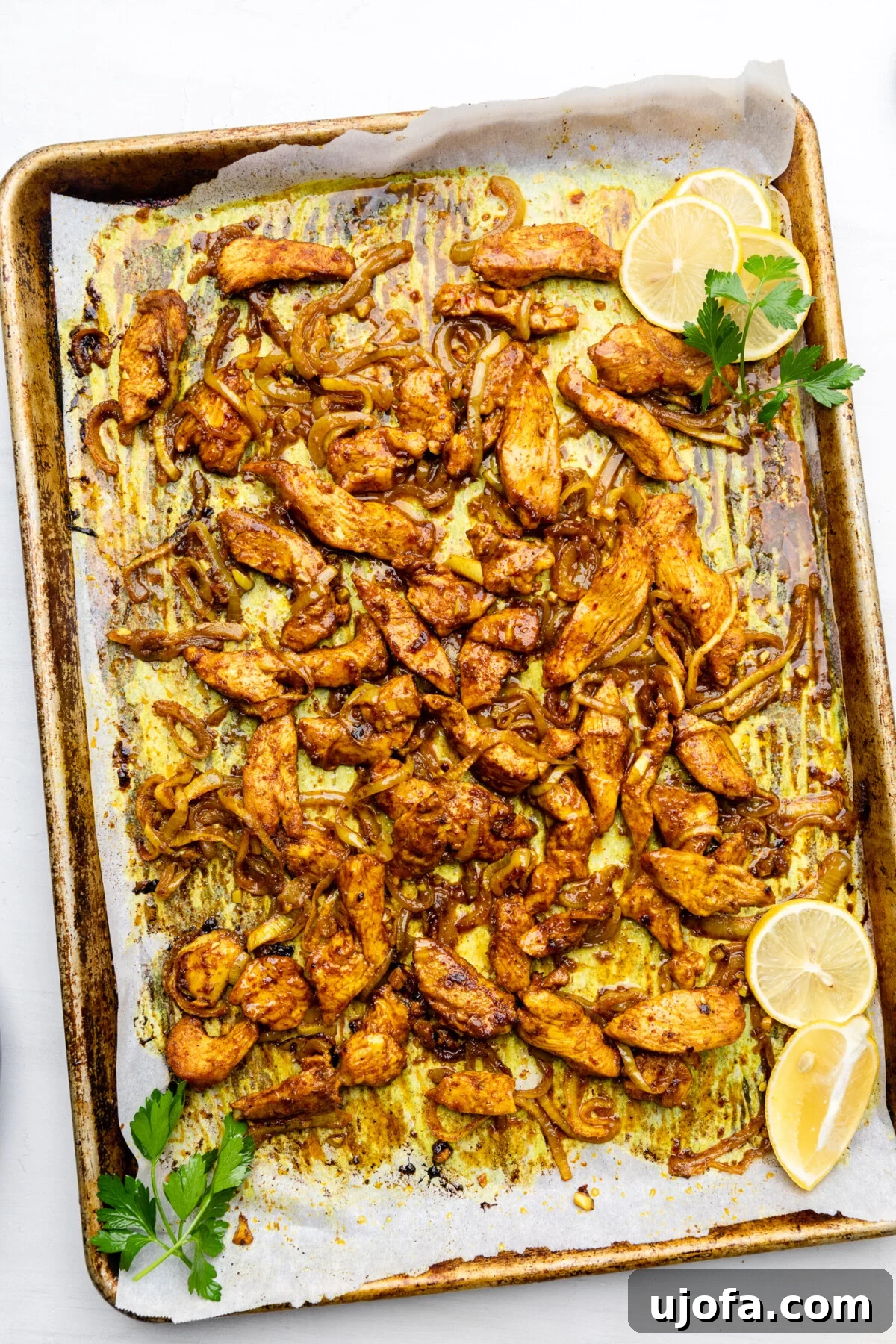 Sheet Pan Chicken Shawarma Power Bowls 8 Perfectly baked marinated chicken and caramelized onions on a lined baking sheet, golden brown and ready to serve.