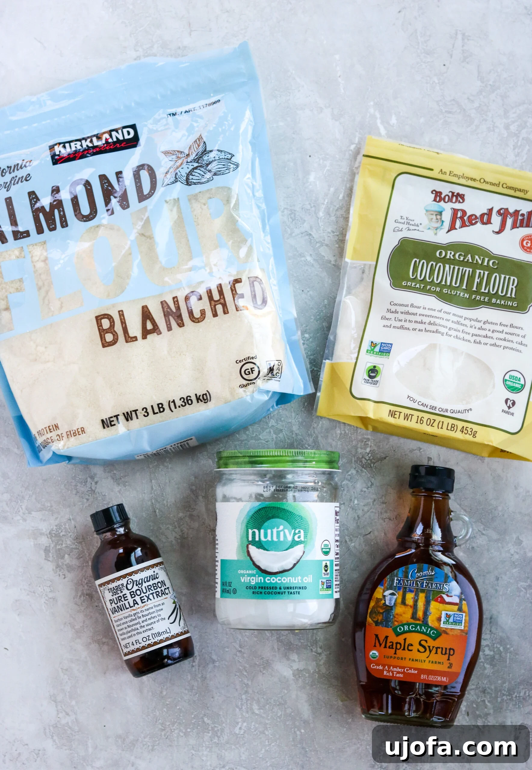 Ingredients for vegan shortbread crust: Almond flour, coconut flour, vanilla extract, coconut oil, and maple syrup are neatly arranged.