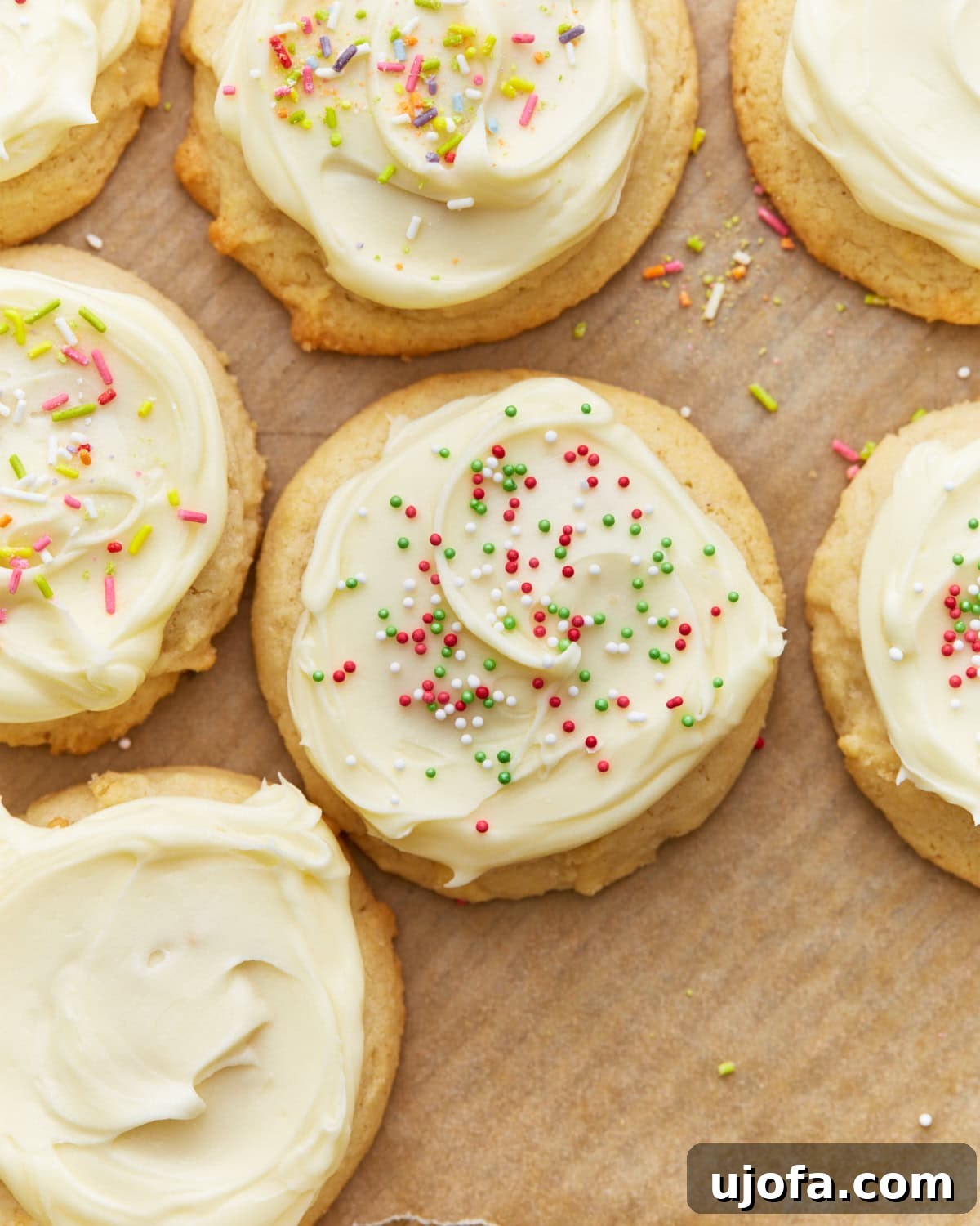 Simply Sweet Gluten-Free Cookies 2 Overhead view of perfectly iced gluten-free sugar cookies adorned with festive sprinkles, neatly arranged on a parchment-lined baking sheet.