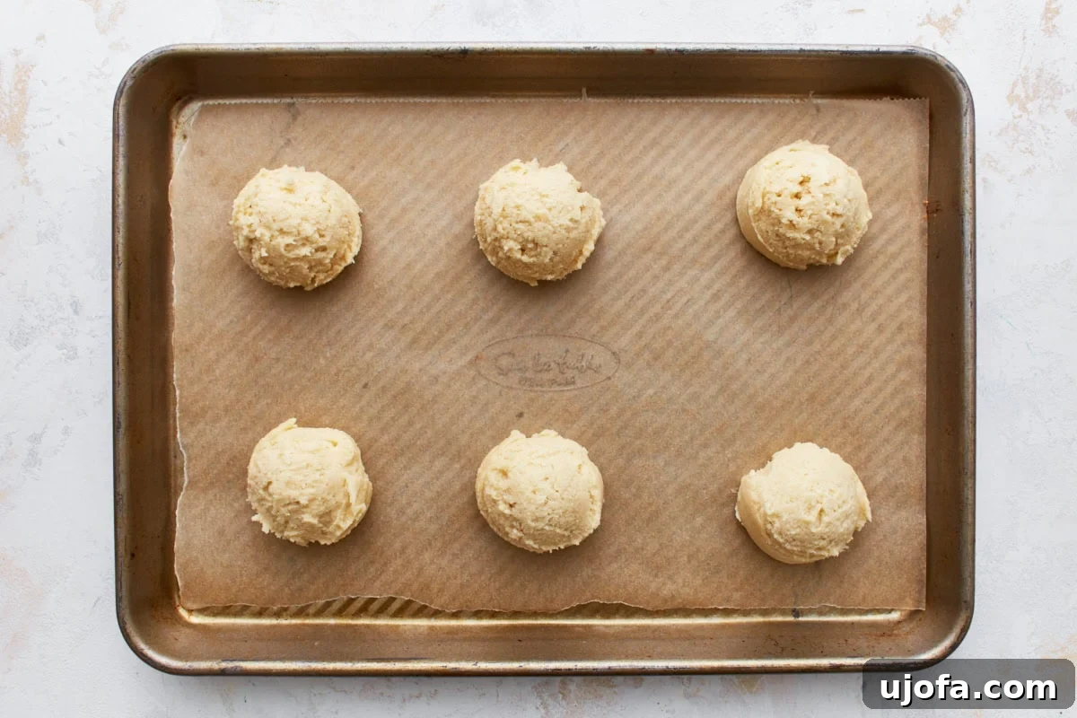 Simply Sweet Gluten-Free Cookies 11 Portions of gluten-free sugar cookie dough, neatly scooped and spaced two inches apart on a parchment-lined baking sheet, prepared for the oven.