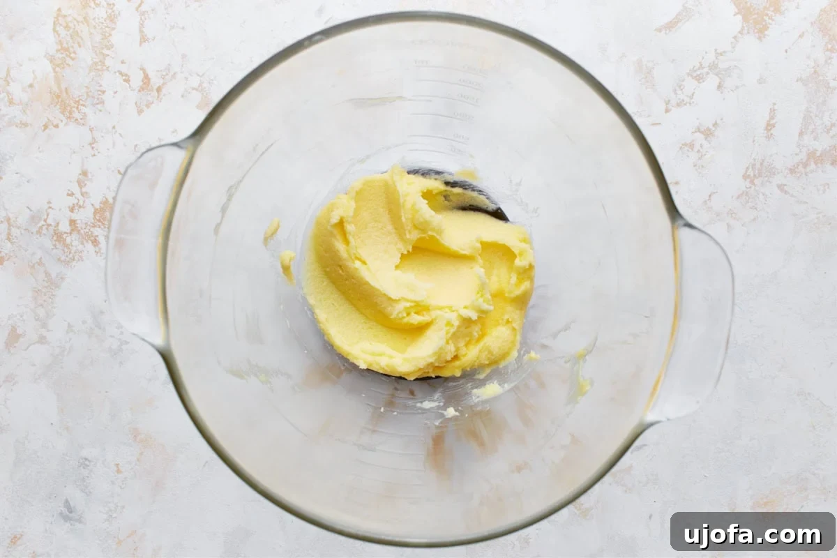 Simply Sweet Gluten-Free Cookies 7 Creamy mixture of softened butter and granulated sugar in a clear glass mixing bowl, ready for the next steps in the cookie preparation.