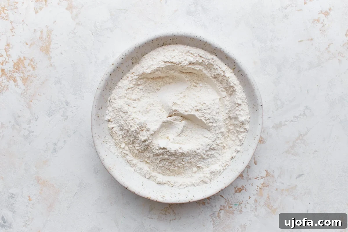 Simply Sweet Gluten-Free Cookies 9 A small glass bowl holding the dry ingredients for gluten-free sugar cookies: gluten-free flour, baking powder, and salt, ready to be stirred.