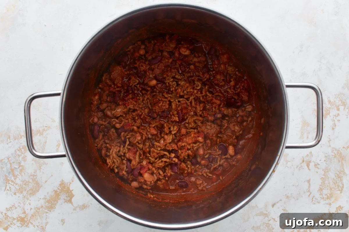 Gluten-free chili simmering in a pot with ground beef and beans