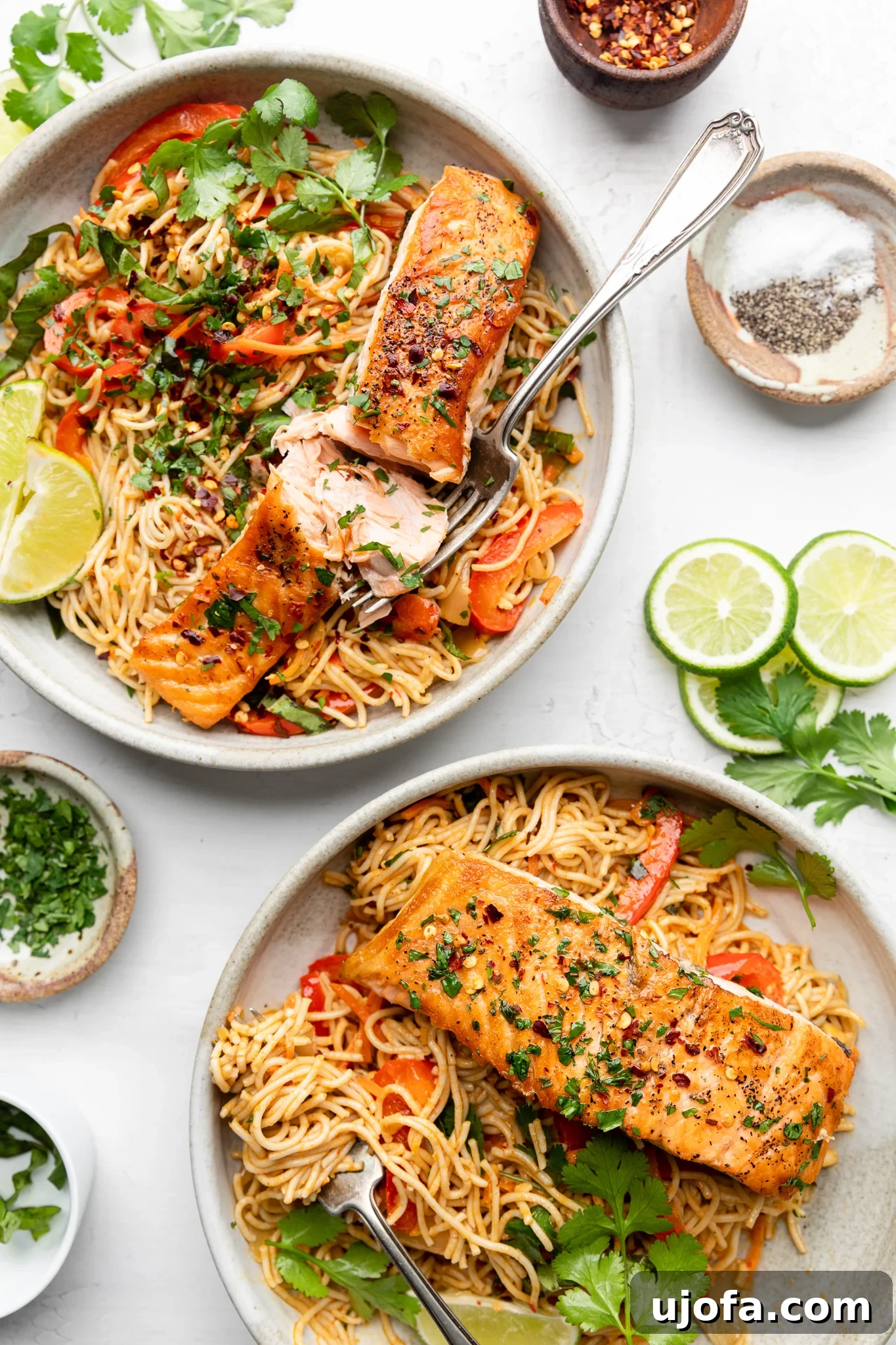 Savory Gluten-Free Thai Curry Salmon Ramen 5 Two bowls of Gluten-Free Thai Curry Salmon Ramen garnished with lime wedges and herbs