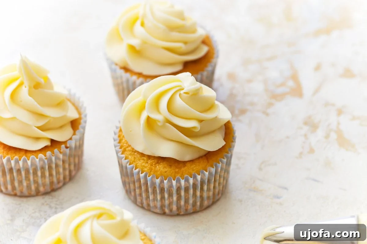 A trio of perfectly baked and frosted gluten-free vanilla cupcakes, ready to be enjoyed.