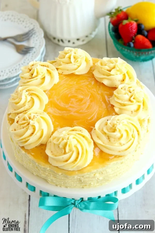 Effortless Gluten-Free Easter Sweets 5 A stunning gluten-free lemon cake with a luscious lemon buttercream frosting, beautifully garnished with fresh berries and lemon slices, with a tea pot and plates blurred in the background.