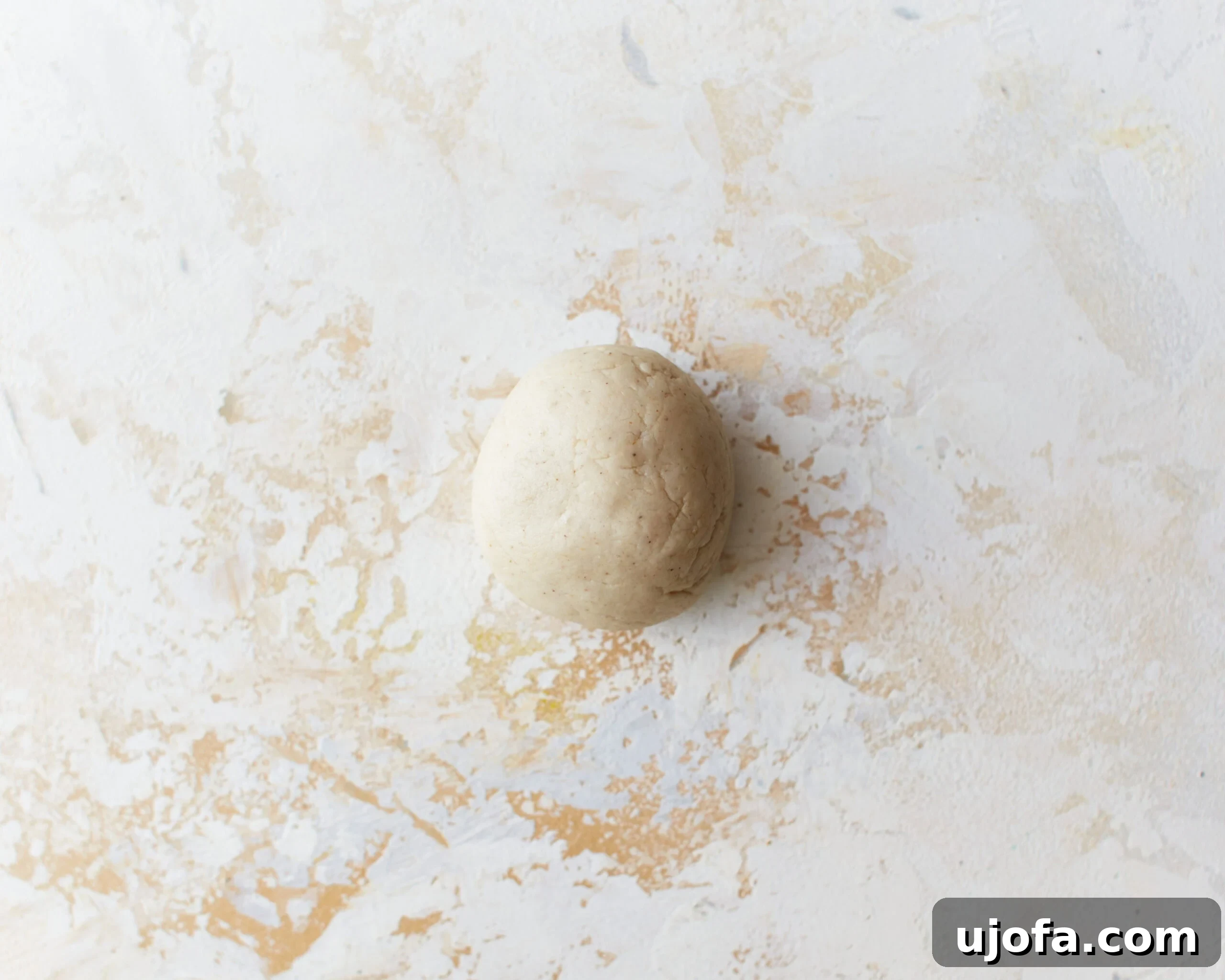 A pristine ball of gluten-free tortilla dough rests on a clean work surface, ready to be divided and rolled out for individual tortillas.