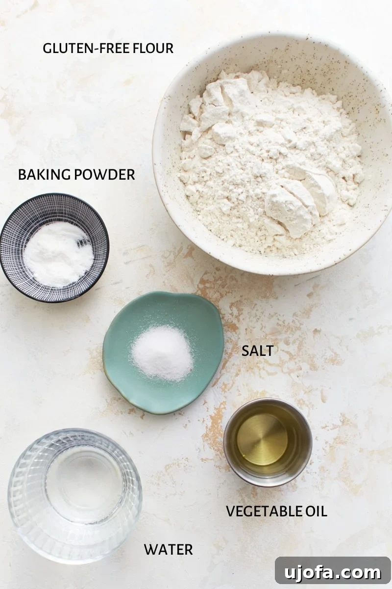 A beautifully arranged display of the five simple ingredients required for gluten-free tortillas: a bowl of flour, baking powder, salt, a bottle of vegetable oil, and a glass of warm water.