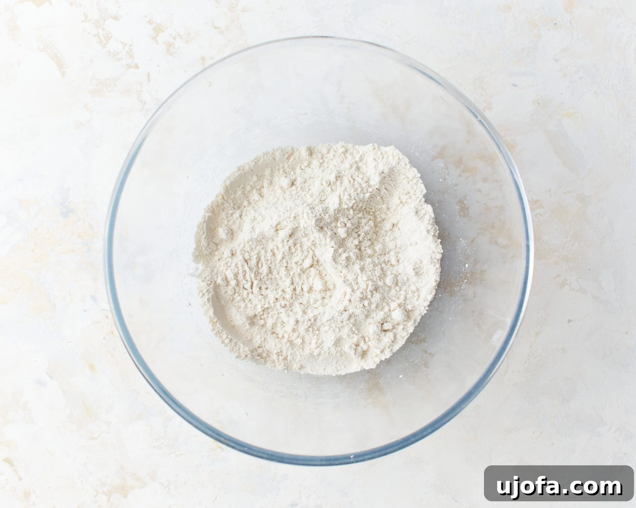 Gluten-free flour, baking powder, and salt precisely measured and combined in a large glass mixing bowl, ready for the wet ingredients.