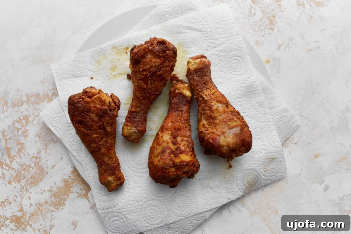Four gluten-free fried chicken drumstick resting on a paper towel
