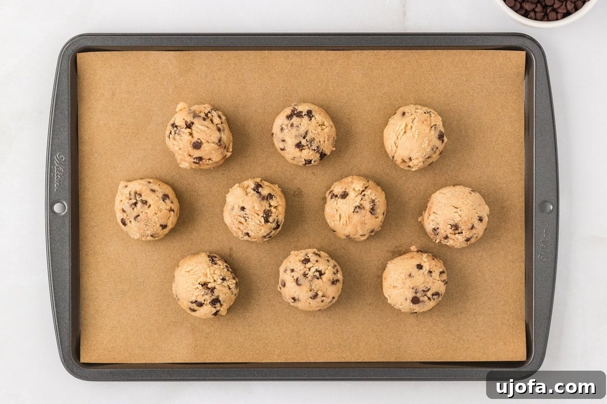 Guilt-Free Gluten-Free Cookie Dough 9 Scoops of gluten-free edible cookie dough arranged on a parchment-lined baking sheet.