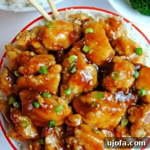 Flavorful Gluten-Free Chicken Feasts 14 A bowl of gluten-free apricot chicken with chopsticks, broccoli and rice in the background, showcasing a vibrant and appealing meal.