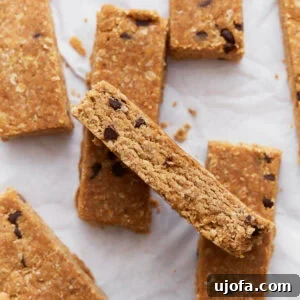 Homemade gluten-free granola bars stacked on parchment paper, showing their golden brown texture and chocolate chip details.