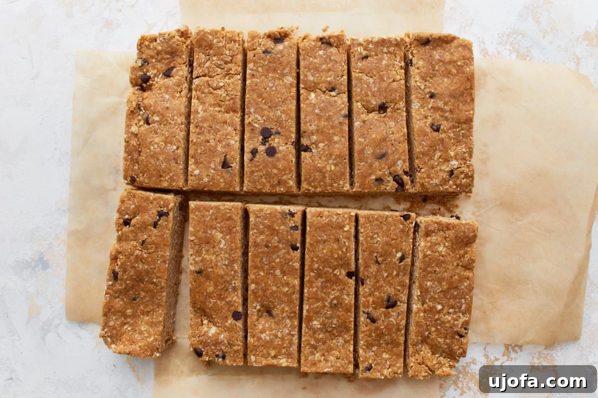 Freshly sliced gluten-free granola bars arranged in even rectangles on parchment paper, showcasing their perfect shape.
