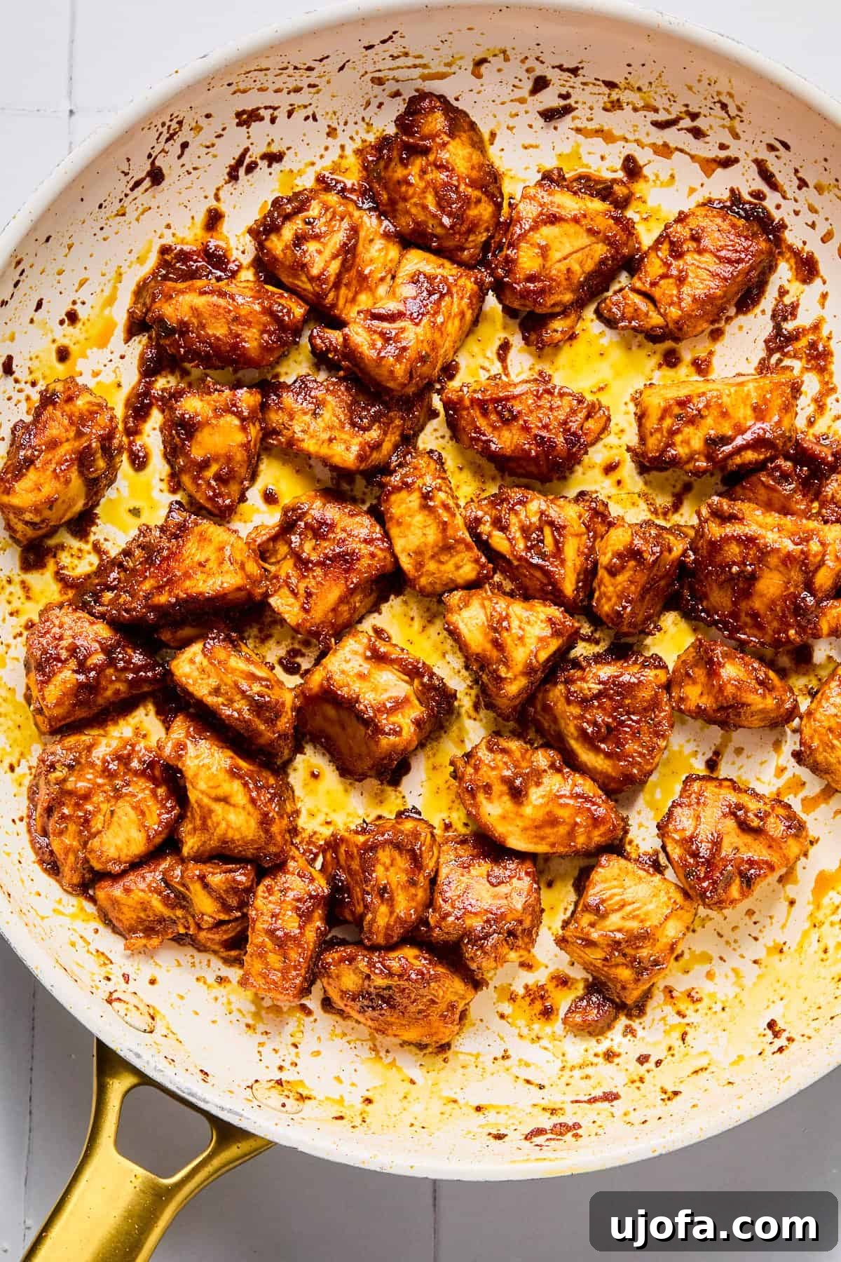 Taco-seasoned chicken breast pieces searing and browning perfectly in a hot skillet, developing a delicious golden crust.