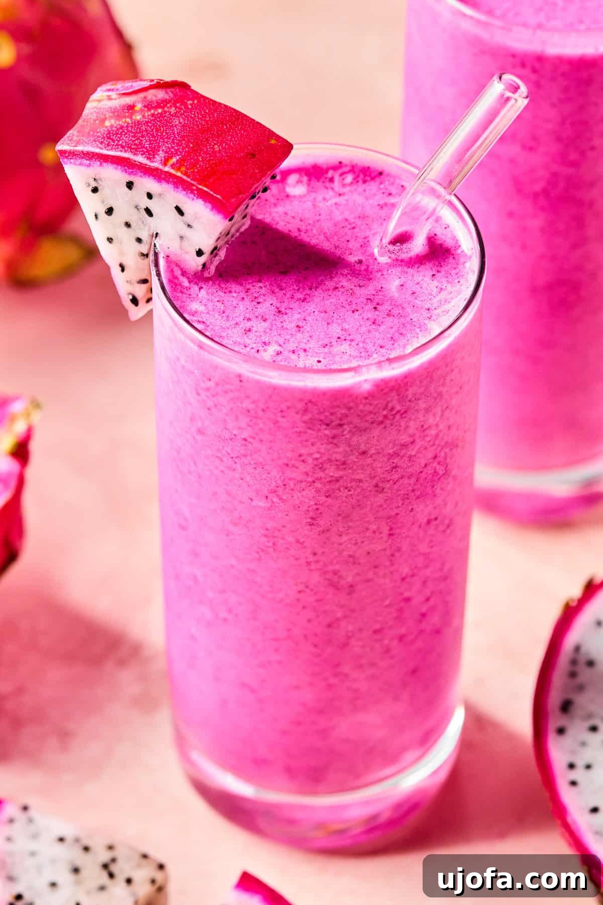 Dragonfruit Power-Up Smoothie 7 Close-up of a creamy dragonfruit smoothie in a glass with a slice of fresh dragonfruit on the rim.