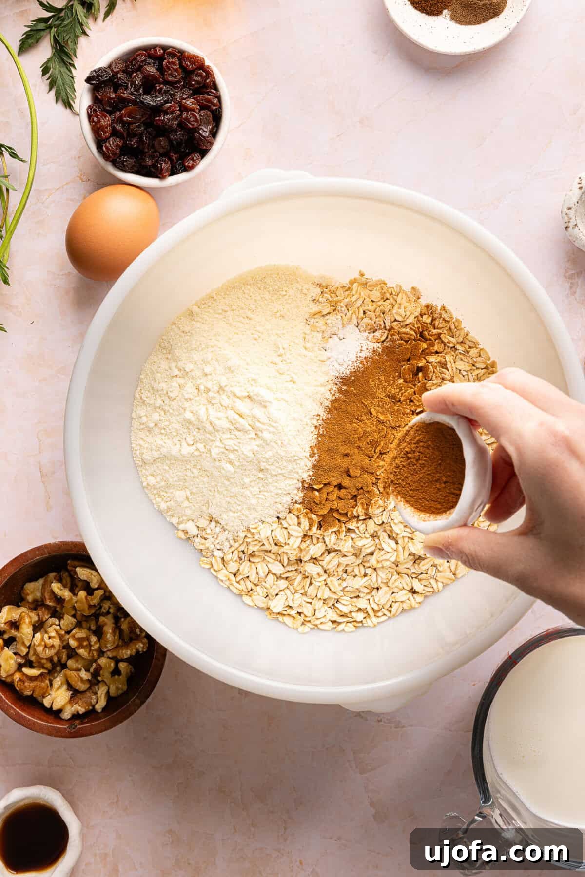 Protein-Packed Carrot Cake Oatmeal Bake 4 Dry ingredients including gluten-free oats, protein powder, and warm spices ready to be mixed together in a large bowl.