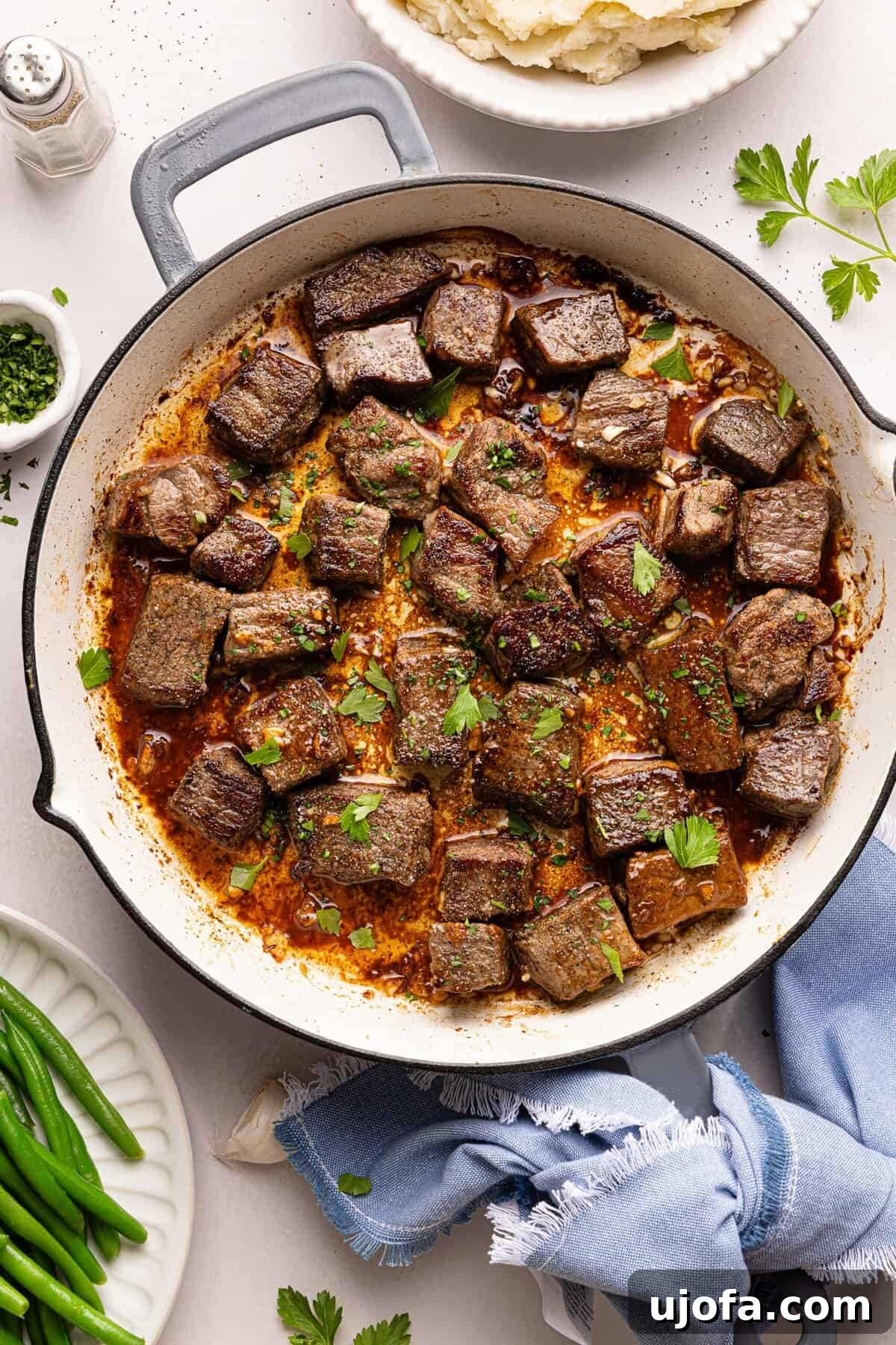 steak bites in a pan with garlic, butter, and parsley
