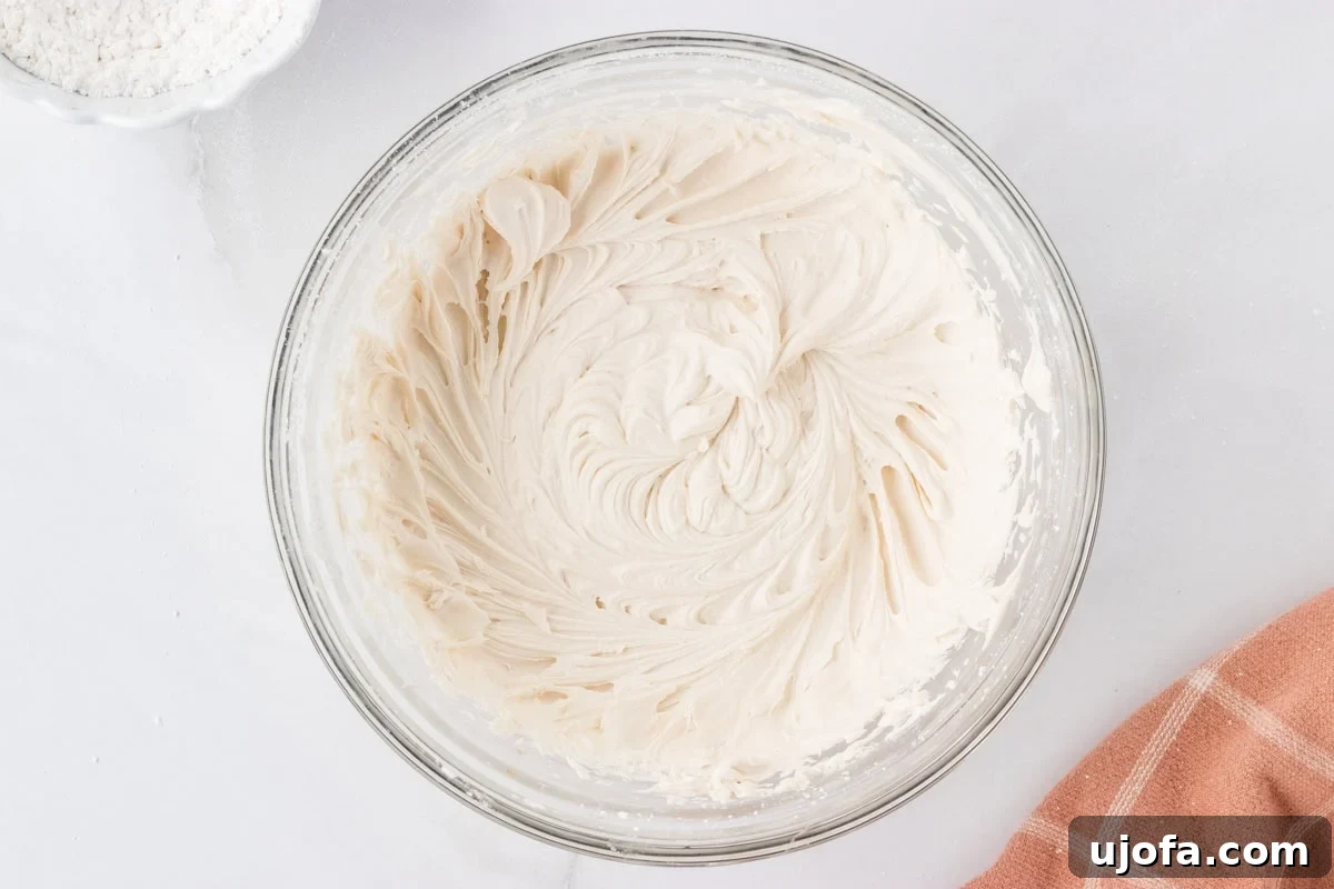 Smooth and fluffy dairy-free buttercream fully mixed in a glass bowl.