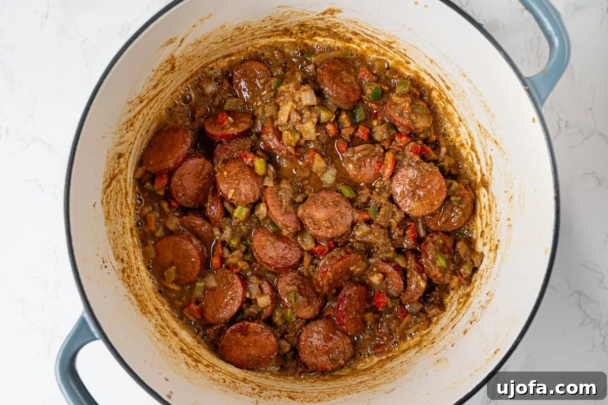 Delectable Gluten-Free Gumbo 12 Shredded chicken, browned andouille sausage, and sautéed vegetables are folded into the thick, dark roux, forming the nascent gumbo base.