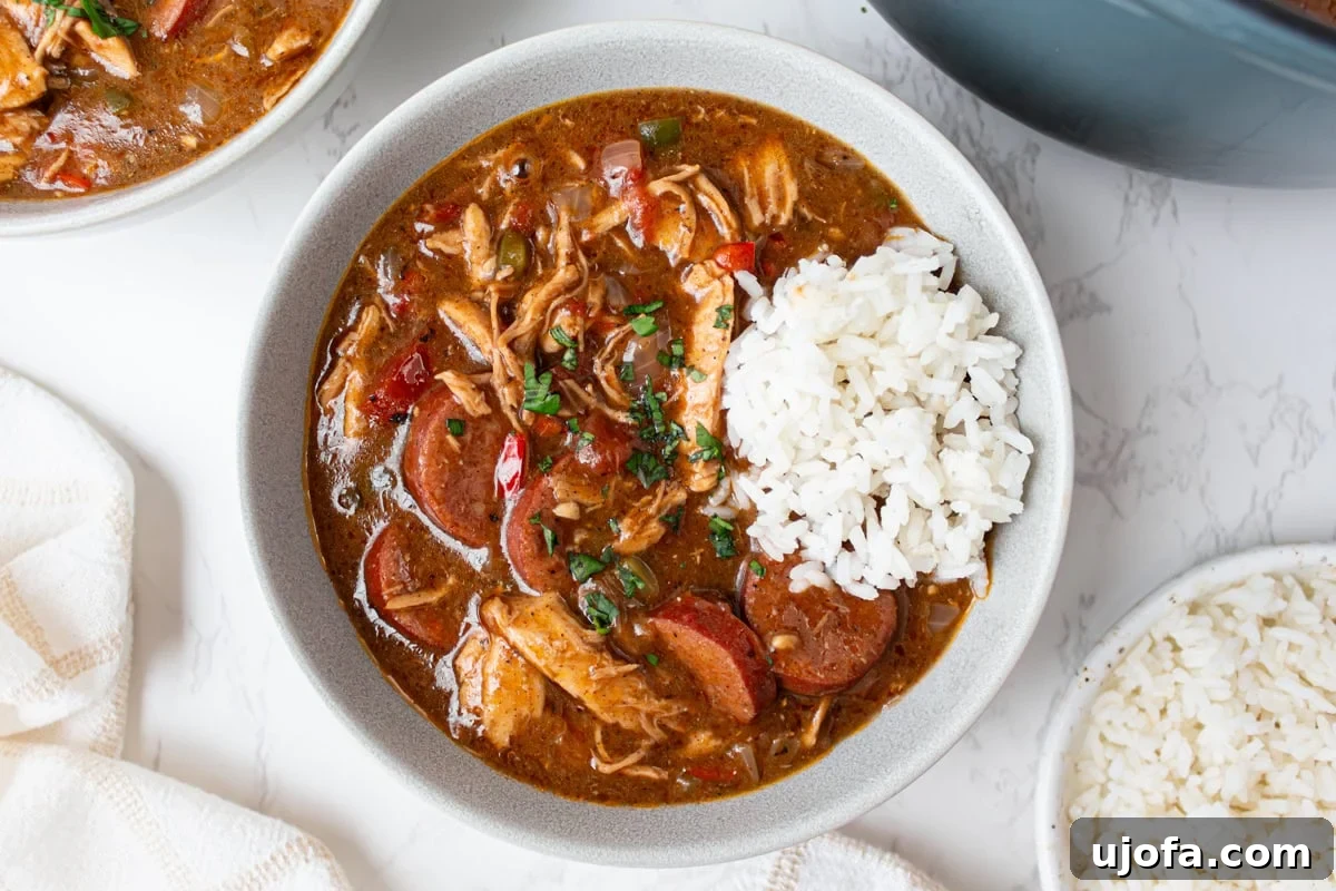 Delectable Gluten-Free Gumbo 15 A steaming bowl of gluten-free gumbo, served over a bed of fluffy white rice and garnished with fresh parsley, ready to be enjoyed.