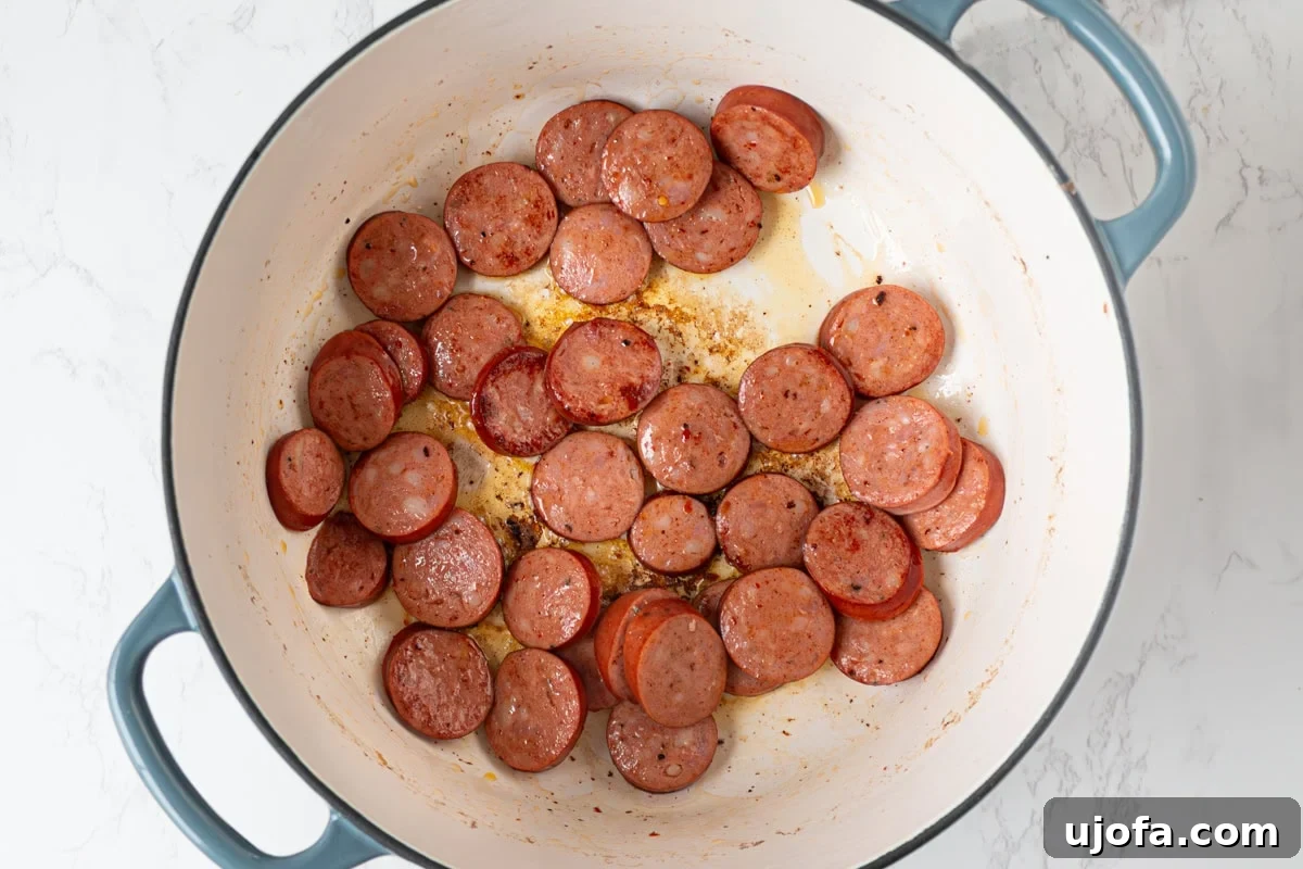 Delectable Gluten-Free Gumbo 8 Slices of spicy andouille sausage browning beautifully in a Dutch oven, leaving behind flavorful drippings.