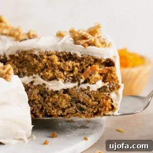 a slice of gluten free carrot cake being pulled out of the whole cake with a spatula