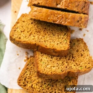 gluten free zucchini bread sliced up on a cutting board with parchment paper